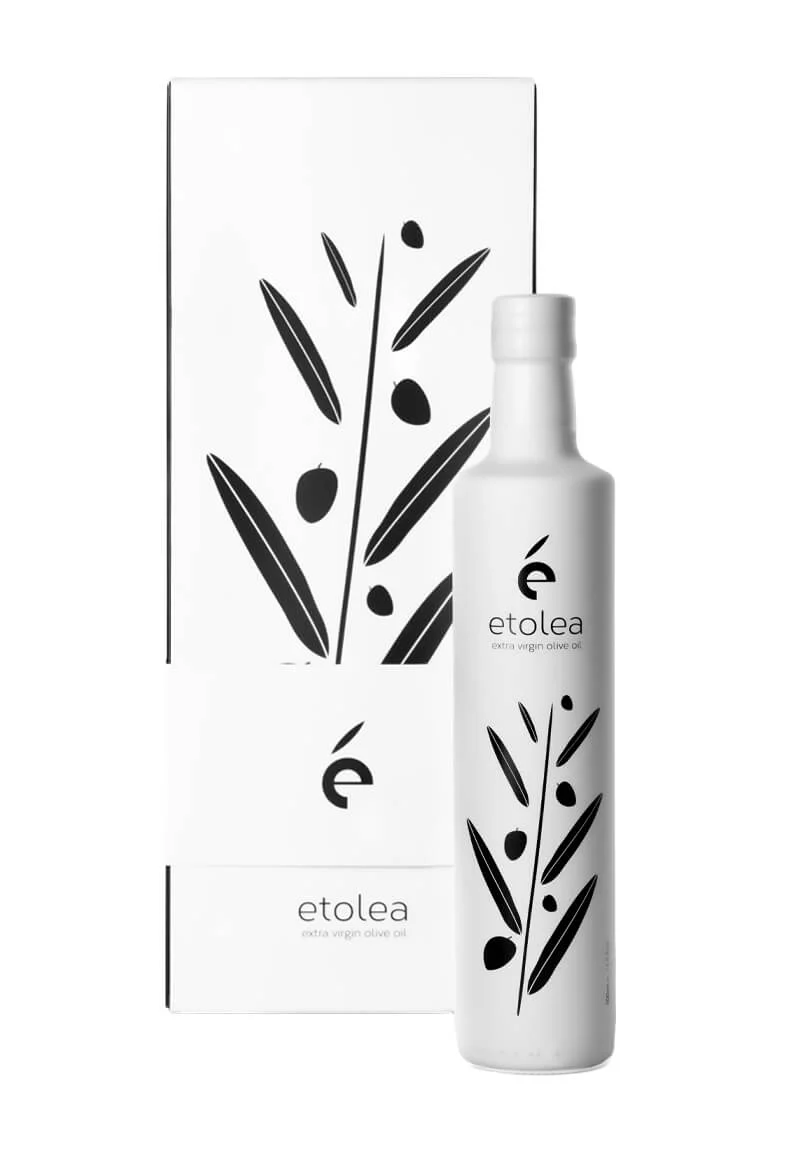 Flasche Etolea White Extra Virgin Olive Oil mit eleganter Verpackung neben einer dekorativen Geschenkbox und Tragetasche.